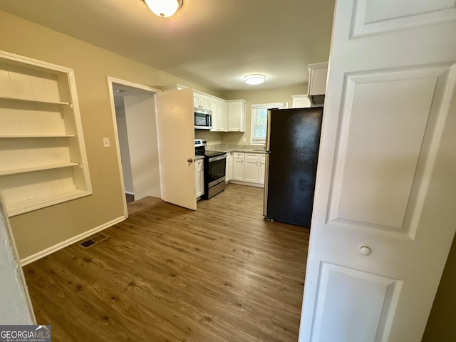 kitchen featuring dark wood-style floors, visible vents, white cabinets, and appliances with stainless steel finishes