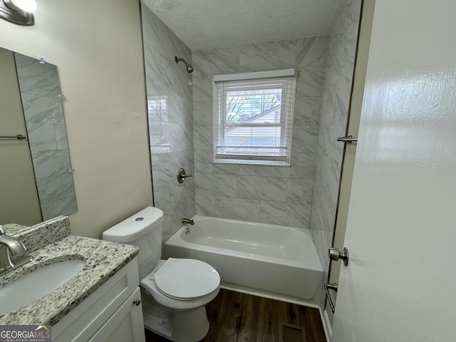 bathroom with vanity, wood finished floors, visible vents, tub / shower combination, and toilet