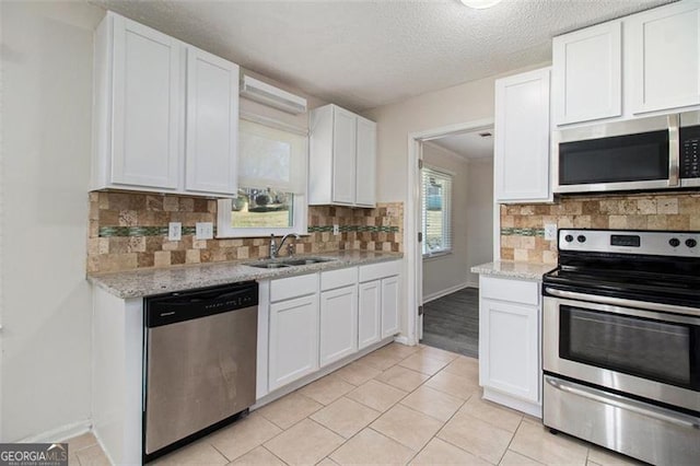 kitchen featuring a sink, stainless steel appliances, white cabinets, and decorative backsplash