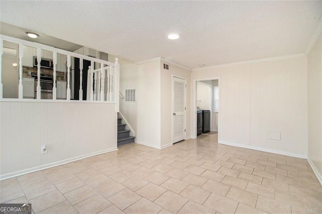 tiled empty room featuring visible vents, a textured ceiling, and ornamental molding