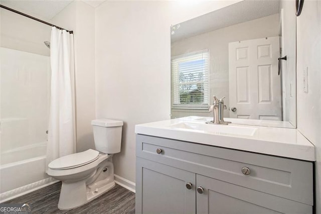 bathroom featuring vanity, toilet, wood finished floors, and shower / tub combo with curtain