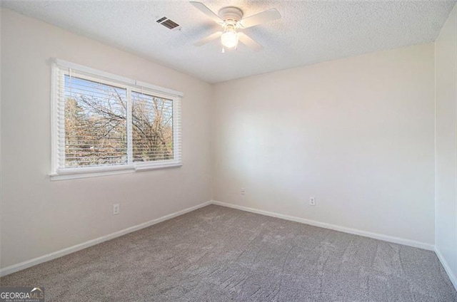 carpeted empty room with a textured ceiling, visible vents, baseboards, and ceiling fan