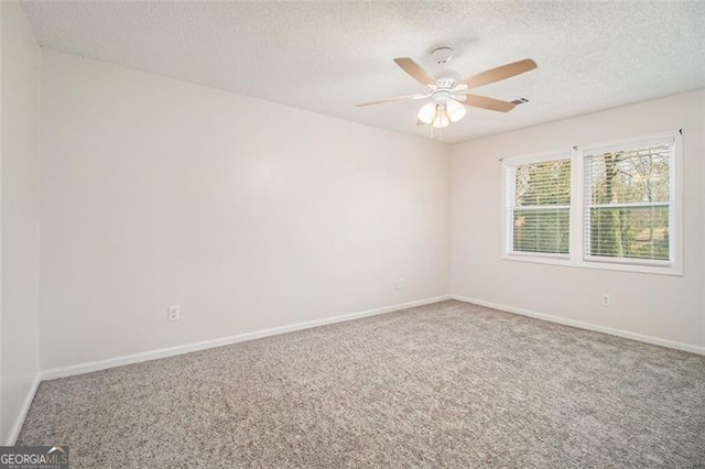 empty room with ceiling fan, a textured ceiling, baseboards, and carpet