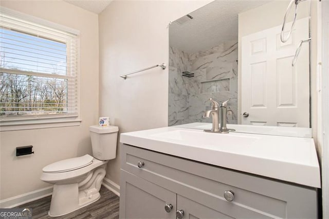 full bath featuring toilet, wood finished floors, a marble finish shower, baseboards, and vanity