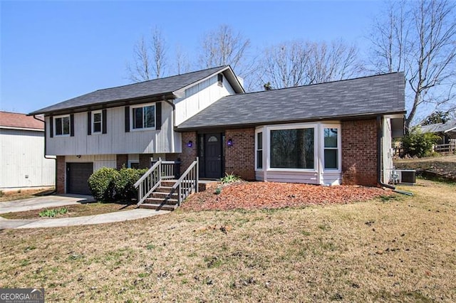 tri-level home with a front lawn, an attached garage, brick siding, and concrete driveway