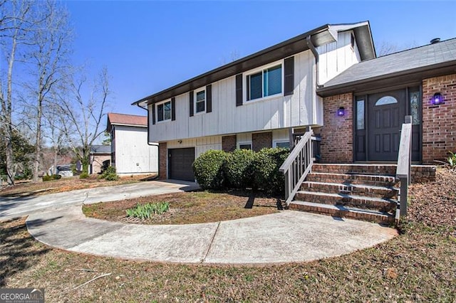 view of front of house with driveway, brick siding, and an attached garage