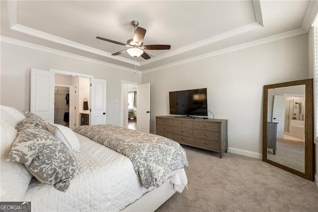 bedroom with a ceiling fan, baseboards, a tray ceiling, light carpet, and crown molding