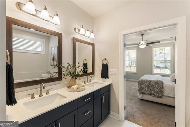 bathroom featuring a healthy amount of sunlight, ensuite bathroom, and a sink