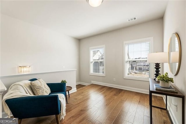 sitting room featuring baseboards, wood-type flooring, and visible vents