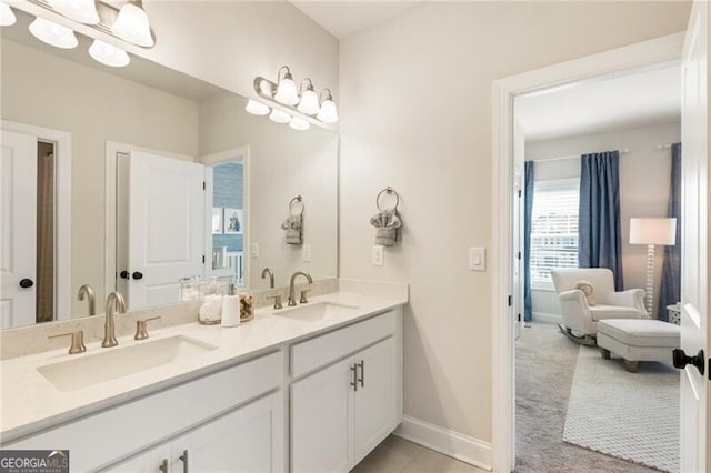 bathroom with a sink, baseboards, and double vanity