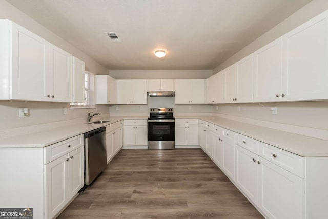 kitchen with visible vents, under cabinet range hood, white cabinets, stainless steel appliances, and a sink