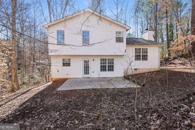 rear view of property featuring a chimney and a patio