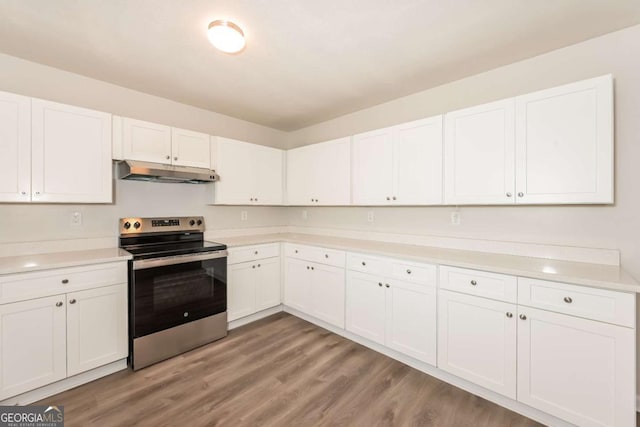 kitchen with under cabinet range hood, stainless steel range with electric stovetop, light wood-type flooring, and light countertops