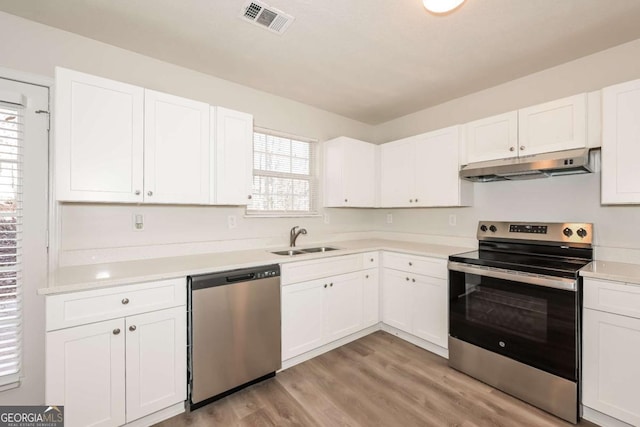 kitchen featuring visible vents, a sink, stainless steel appliances, white cabinets, and under cabinet range hood