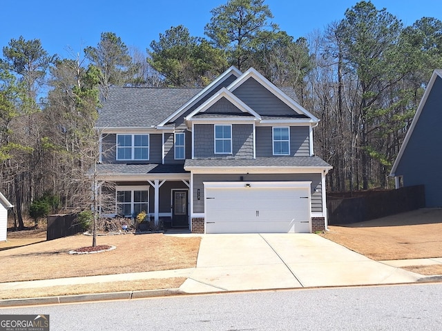 craftsman-style house with a garage, fence, concrete driveway, and a shingled roof