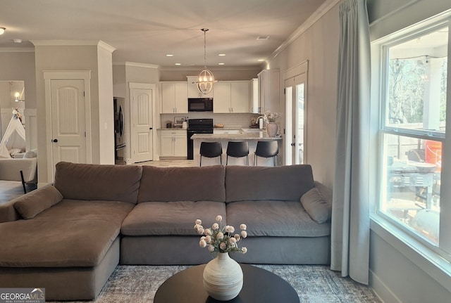 living room with visible vents, a healthy amount of sunlight, and ornamental molding