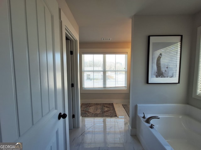 bathroom featuring visible vents, a garden tub, and marble finish floor