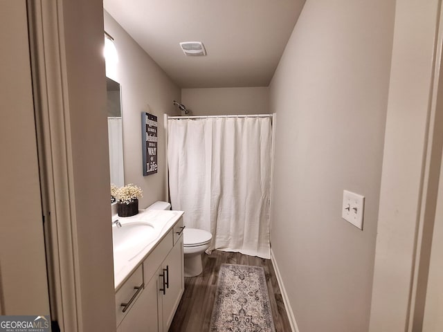 bathroom with visible vents, toilet, a shower with shower curtain, wood finished floors, and vanity