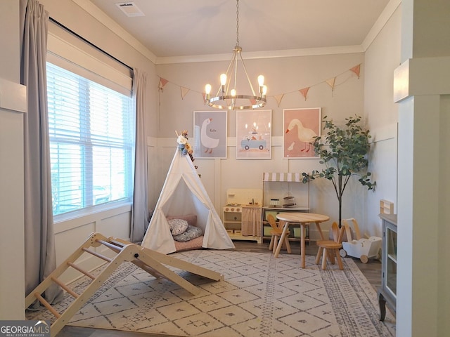 game room with visible vents, a decorative wall, a chandelier, and ornamental molding