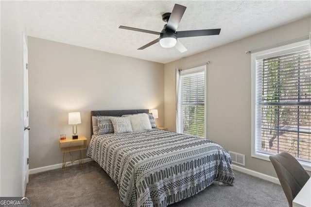 carpeted bedroom with visible vents, a ceiling fan, baseboards, and a textured ceiling