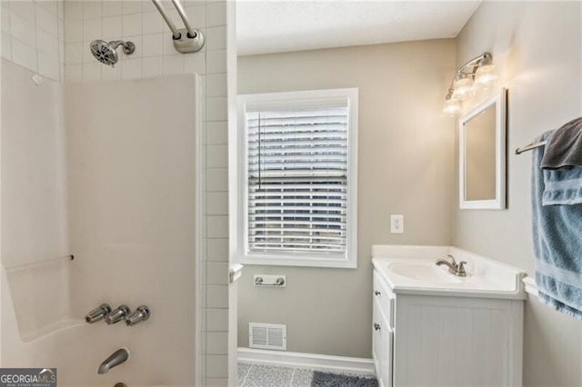 bathroom with baseboards, visible vents, vanity, and  shower combination