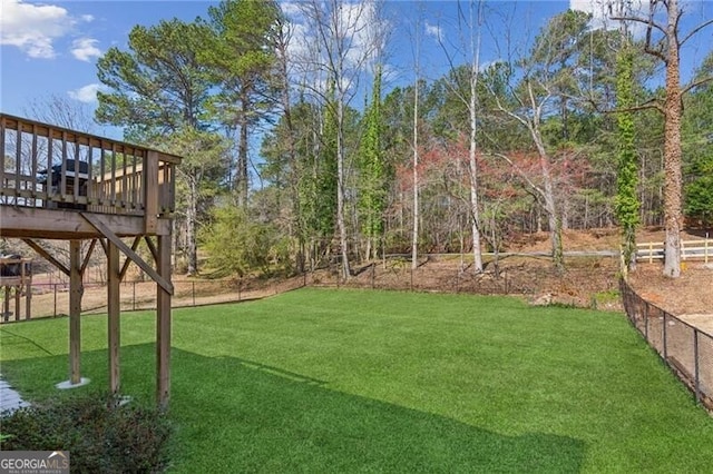 view of yard featuring a deck and fence