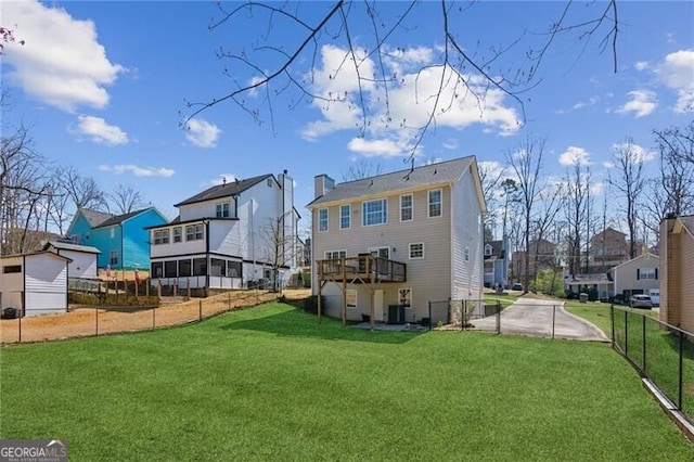 rear view of property with a yard, a residential view, central AC, and fence