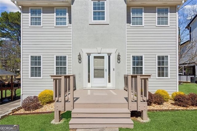 exterior space with stucco siding and a front lawn