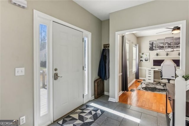 foyer with tile patterned flooring, baseboards, and ceiling fan