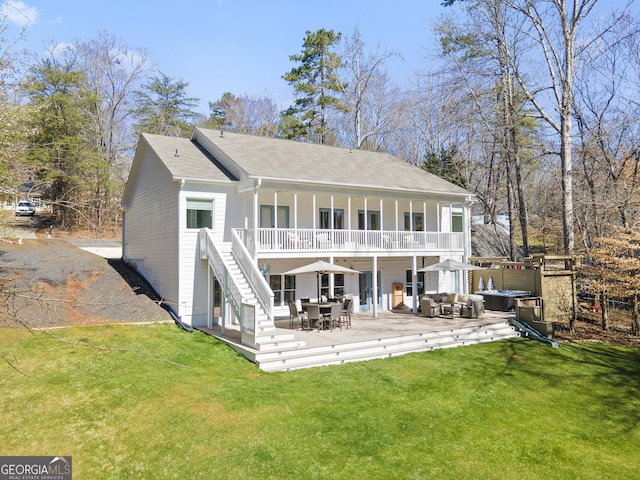 back of property featuring stairway, a lawn, and outdoor lounge area