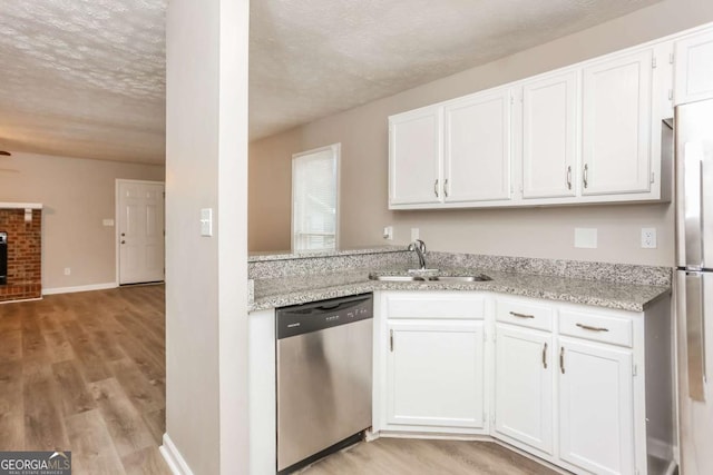 kitchen with white cabinets, light wood-style flooring, appliances with stainless steel finishes, and a sink