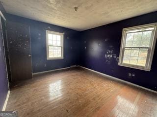 empty room with baseboards and wood finished floors