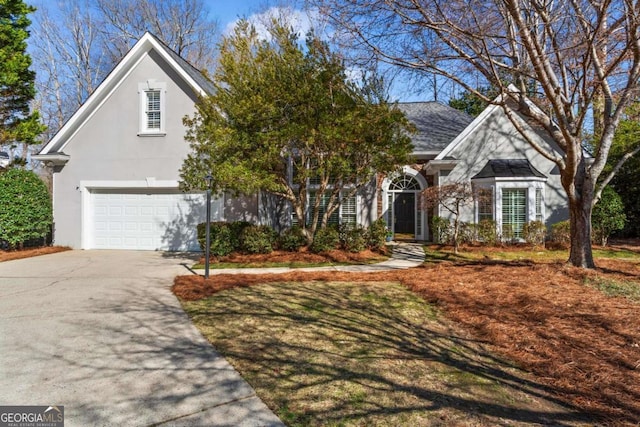 view of front of home featuring stucco siding, driveway, an attached garage, and roof with shingles