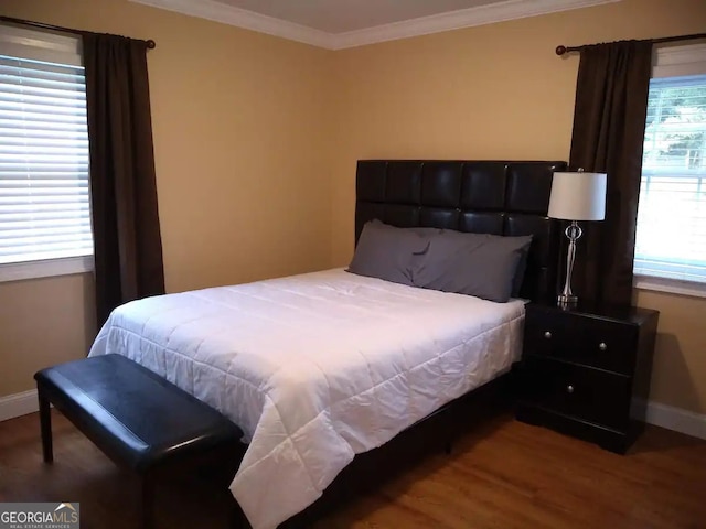 bedroom featuring crown molding, wood finished floors, and baseboards