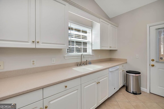 kitchen featuring dishwasher, vaulted ceiling, light tile patterned floors, white cabinets, and a sink