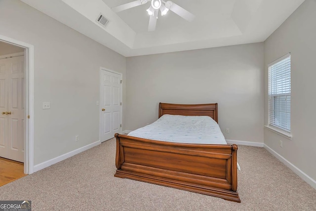 bedroom with a raised ceiling, baseboards, and visible vents