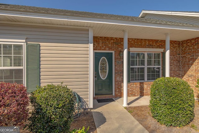 view of exterior entry featuring brick siding