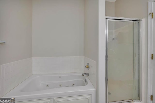 bathroom featuring a jetted tub and a shower stall