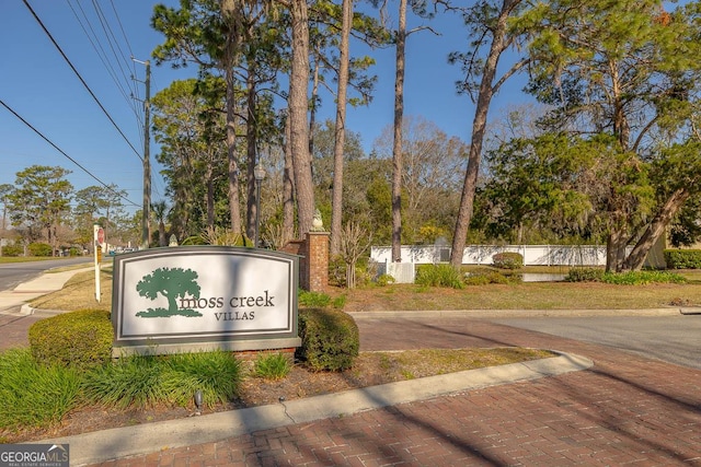 community / neighborhood sign featuring fence