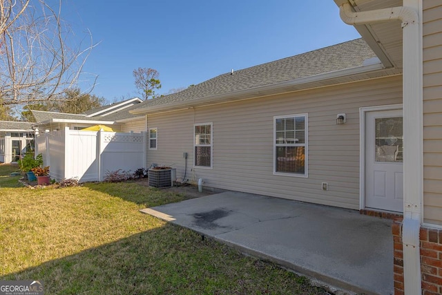 back of property with a patio, fence, a yard, central AC, and a shingled roof