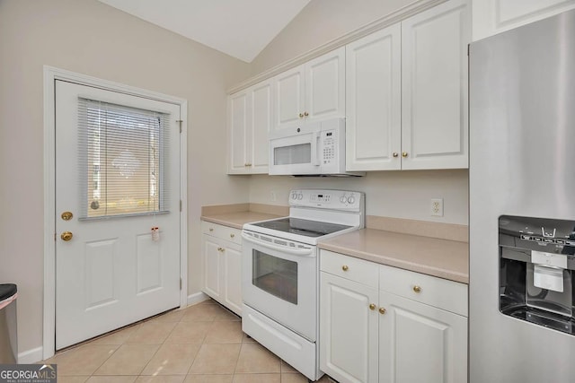 kitchen with white appliances, light tile patterned flooring, light countertops, white cabinets, and vaulted ceiling