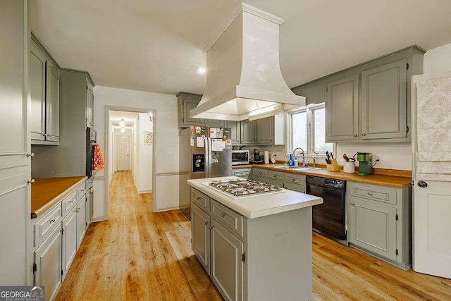 kitchen featuring a sink, gray cabinetry, appliances with stainless steel finishes, and island range hood