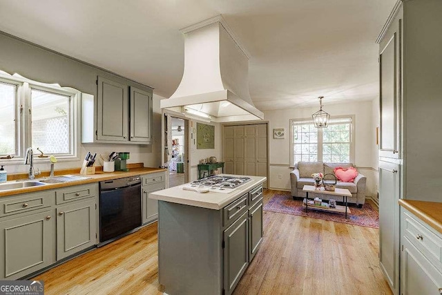 kitchen featuring white gas cooktop, light wood finished floors, light countertops, dishwasher, and island range hood