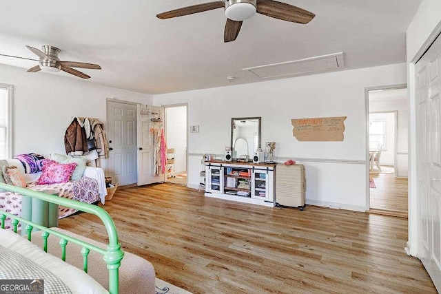 bedroom with ceiling fan, baseboards, attic access, and wood finished floors