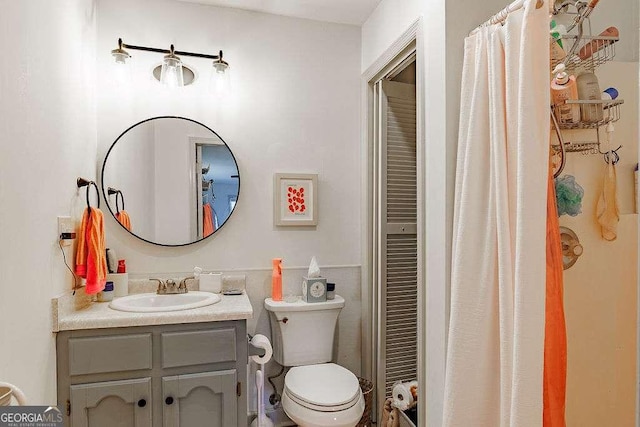 bathroom with vanity, curtained shower, and toilet