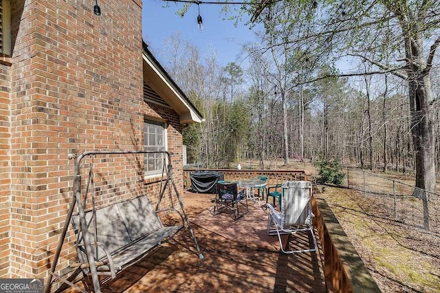 view of patio featuring a deck, outdoor dining area, and fence