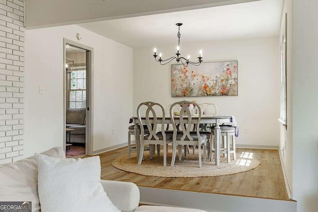 dining area with a notable chandelier, baseboards, and wood finished floors