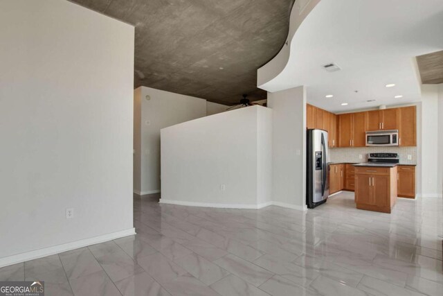 kitchen featuring dark countertops, visible vents, a kitchen island, decorative backsplash, and appliances with stainless steel finishes