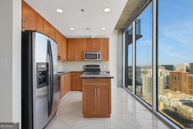 kitchen with tasteful backsplash, visible vents, brown cabinets, appliances with stainless steel finishes, and a view of city