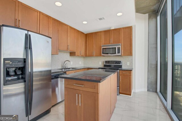 kitchen featuring visible vents, dark countertops, a center island, appliances with stainless steel finishes, and decorative backsplash